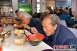 图为老人正在吃饭。当日的午饭是烩菜、花卷、馒头。 - 甘肃新闻