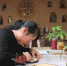 图为张燕林在客栈中雕刻敦煌壁画主题的木版画。　徐雪 摄 - 甘肃新闻
