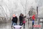 3月11日至13日，甘肃出现今年最强暴雪天气。图为12日下午银装素裹的兰州黄河风情线上，民众在春雪中游玩。　杨艳敏 摄 - 甘肃新闻
