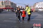 图为兰州交警带领孩童通过马路。　　　魏立武 摄 - 甘肃新闻