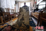 王选成展示收藏的古毯。　杨艳敏 摄 - 甘肃新闻