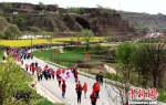 现场数千名徒步爱好者组成的“健步行”队伍，从毛寺村向终点北石窟寺进发。　盘小美 摄 - 甘肃新闻