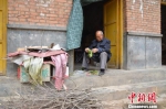 一位“陪读”的家长坐在出租屋门口择菜。　冯志军 摄 - 甘肃新闻