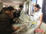 10月18日下午，王秀章携手五名甘肃籍画家在模特服装上手绘，创作了一系列含有中国元素的的画作。　史静静 摄 - 甘肃新闻