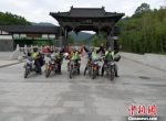 郝学生(左一)与“摩友”骑摩托车去江苏省南云台山中麓，在花果山景区门前合影留念。 受访人提供 - 甘肃新闻