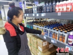 12月12日，兰州新区进口商品批发中心百货区经理李志娟为顾客介绍韩国洗发水的作用及功效。　闫姣 摄 - 甘肃新闻