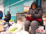 图为张菊芳老人正在卖菜。　甘芬 摄 - 甘肃新闻