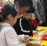 寒假到来，兰州200多名幼儿穿着古装，吃着冰糖葫芦，在家长的带领下，买灯笼、学剪纸，提前感受“中国年”气氛。图为，小朋友在家长陪伴下买灯笼等。　刘玉桃 摄 - 甘肃新闻