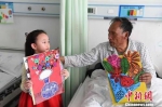 图为6岁的小女孩赵晋艺为病房里的老人送画。　杨艳敏 摄 - 甘肃新闻