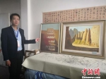 图为牛浩东介绍他的绘画代表作品《敦煌印象》与《黄河石林》。　崔琳 摄 - 甘肃新闻