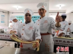 　图为来自哈萨克斯坦的留学生赤龙展示拉出的“毛细”面型。毛细是牛肉面中最细的一道面食，成型后“细如发丝”。　史静静 摄 - 甘肃新闻