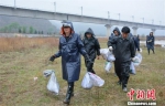 图为搬运活性炭。　平凉市政府网图片 摄 - 甘肃新闻