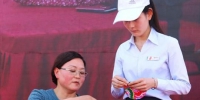 4月19日，在甘肃庆阳市举办的“小崆峒旅游文化节”上，当地民间手工艺传承人在向游客教授剪纸技艺。　陈飞 摄 - 甘肃新闻