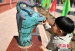图为小朋友观看陶瓷制作的十二生肖头像。　刘玉桃 摄 - 甘肃新闻