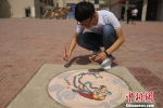 图为学生在井盖作画。　刘玉桃 摄 - 甘肃新闻