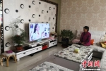 图为惠玉珠的妻子在客厅看电视。　刘玉桃 摄 - 甘肃新闻