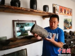 图为彭维国展示他从村里废墟上淘来的冶铁工具。　魏建军 摄 - 甘肃新闻