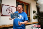 图为彭维国讲述他收藏的门牌号背后“消失的村庄”。　魏建军 摄 - 甘肃新闻