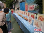 图为家长参观展出的小学生非遗作品。　杨娜 摄 - 甘肃新闻