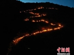 6月14日至18日，第三届陇南文县白马人·民俗文化旅游节举行。图为火把星星点点从山顶奔腾而下，顺着蜿蜒山路呈现“S”形。　杨艳敏　摄 - 甘肃新闻