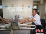 图为48岁的安君强在金昌无障碍厕所洗手。　魏建军 摄 - 甘肃新闻