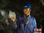 图为镜铁山矿桦树沟矿区工作人员介绍开采出来的铁矿石。　魏建军 摄 - 甘肃新闻
