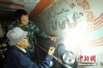 图为李云鹤在莫高窟姊妹窟榆林窟中修复壁画。(杨艳敏 摄) - 甘肃新闻