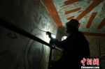 图为85岁的李云鹤打开灯，戴着老花镜开始修复工作。　杨艳敏 摄 - 甘肃新闻