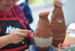 图为陶艺师使用马家窑纹样制作现代陶艺。　崔琳 摄 - 甘肃新闻