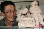图为赵铁军正在观看制作完成的人物泥塑。　郭惠民 摄 - 甘肃新闻
