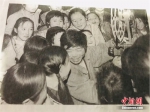 图为尹凤民正在放电影，他被一群孩子围在中间。(翻拍于报纸)闫姣 摄 - 甘肃新闻