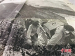图为尹凤民和妻子“翻山越岭”，背着沉重的设备为村民们放电影。(翻拍于报纸)闫姣 摄 - 甘肃新闻