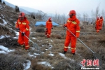 图为护林员拿着铁扫帚巡山护林，做好冬季防火工作。　郭红 摄 - 甘肃新闻