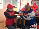 樊恒东(左)给甘肃榆中县北山的魏家台教学点小学生送学习用品。　许岗 摄 - 甘肃新闻