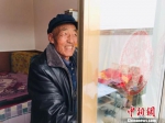 67岁的村民金富贵擦拭着新房子的玻璃。　艾庆龙 摄 - 甘肃新闻