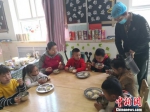 图为老师与小朋友一起用餐。　杨娜 摄 - 甘肃新闻