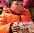 图为当地儿童怀抱“营养包”。　闫姣 摄 - 甘肃新闻