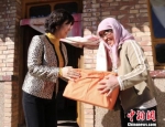 甘肃省妇女儿童基金会负责人周华(左)为定西市渭源县大安乡单亲母亲们送去了“爱心包”。　闫姣 摄 - 甘肃新闻