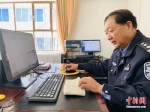 李生寿指着电脑屏幕，手里拿着一个“年代感”十足的新华字典。高康迪 摄 - 甘肃新闻