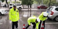 图为甘肃酒泉市交警疏通下水。　李健 摄 - 甘肃新闻