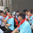 图为小学生为前来进行乐器表演的七里河区老年大学学员佩戴红领巾。　杨娜 摄 - 甘肃新闻