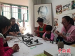刘雪玲和孩子家长一起创作泥塑作品。　钟欣 摄 - 甘肃新闻