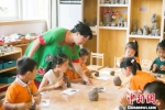 图为刘雪玲正在给幼教中心的孩子上泥塑课。　钟欣 摄 - 甘肃新闻