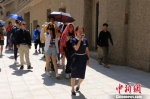 图为敦煌莫高窟志愿者讲解员正在带领游客参观。　敦煌研究院供图 摄 - 甘肃新闻