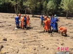 图为7月29日迭部县山洪灾害现场，民间救援队和消防员正在进行清淤。　钟欣 摄 - 甘肃新闻