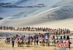 2019年7月18日，中外游客在敦煌鸣沙山月牙泉景区骑骆驼观光游览，形成近2公里长的宛如长龙的观光驼队。(资料图) 王斌银 摄 - 甘肃新闻