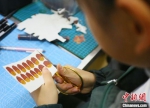 图为小学生将马克笔涂色的纸片进行裁剪。　高展 摄 - 甘肃新闻