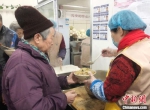 图为志愿者为老人盛饭。　徐雪 摄 - 甘肃新闻