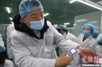 图为工人对生产的电子测温枪进行测试。　刘枫 摄 - 甘肃新闻