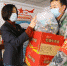 图为兰州市城关区草场街街道党工委副书记王芝萍给卡口点人员分发物资。　高展 摄 - 甘肃新闻